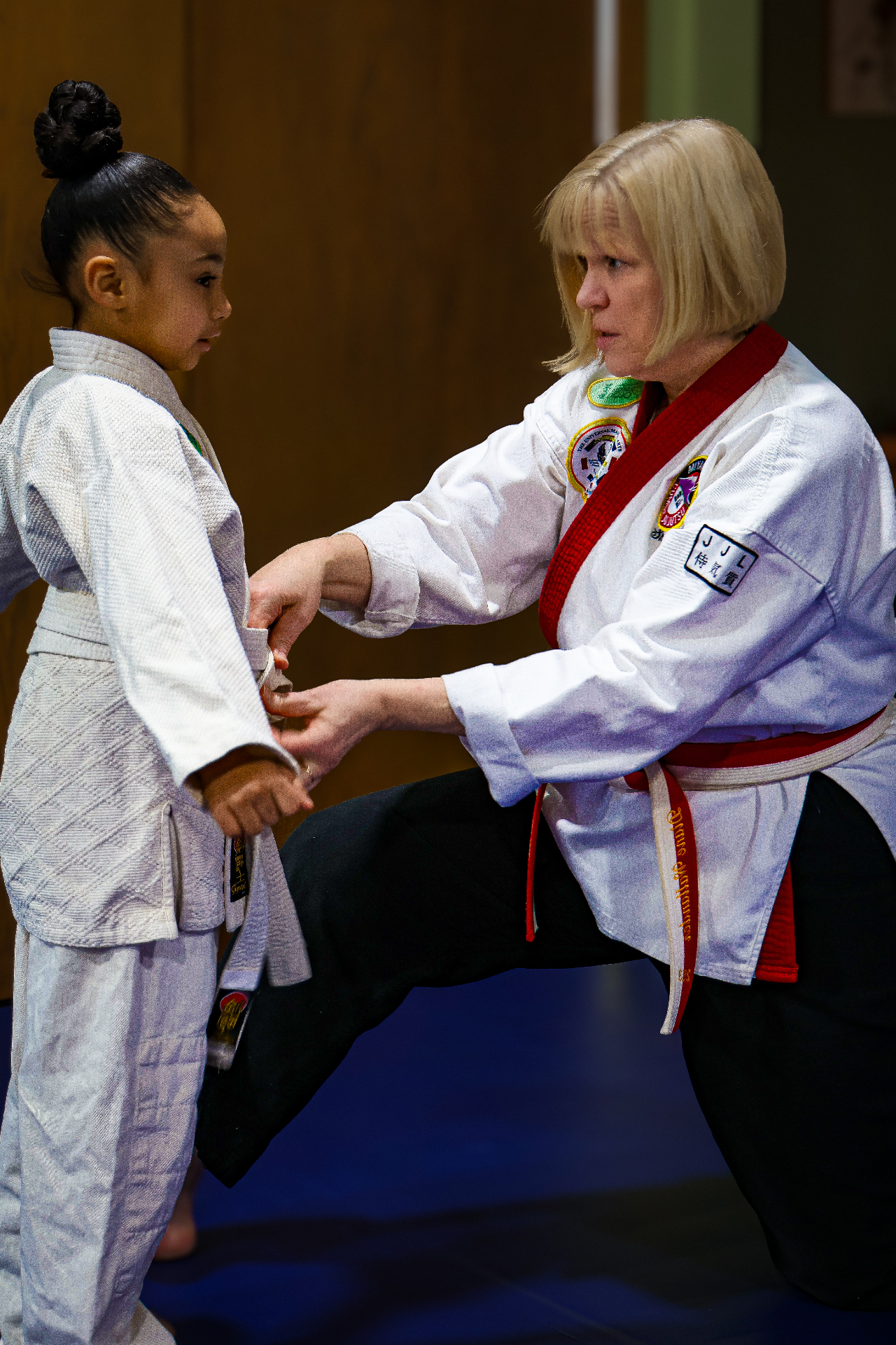 Shihan Diane tying a belt for a young student